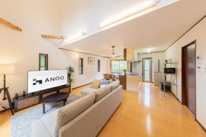 salon z kanapą i telewizorem w obiekcie ANGO ATAMI I w mieście Atami