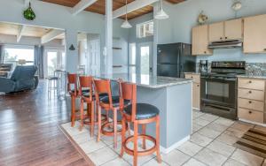 a kitchen with a large island with bar stools at The Strand at Twin Rocks in Rockaway Beach