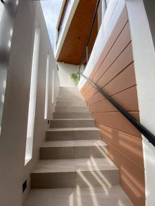 eine Treppe in einem Gebäude mit weißen Wänden und Holzdecken in der Unterkunft The Sunset House in Lucban