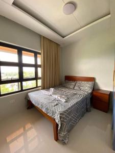 um quarto com uma cama e uma janela em The Sunset House em Lucban