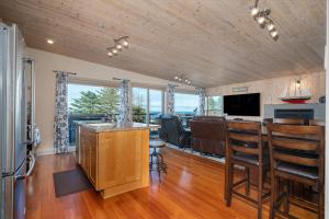 a kitchen with a bar and a living room at Tranquility Cove in Depoe Bay