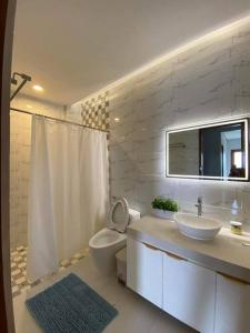ein weißes Bad mit einem Waschbecken und einem WC in der Unterkunft The Sunset House in Lucban