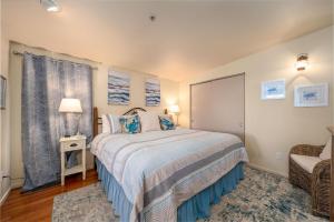 a bedroom with a bed and a chair at Tranquility Cove in Depoe Bay