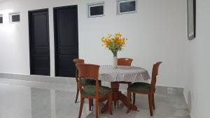 un tavolo e delle sedie con sopra un vaso di fiori di Rumah Benhil, Bendungan Hilir - Senayan a Giacarta