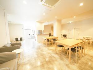 OiseSun CAFE & HOTEL في Hyuga: غرفة فارغة مع طاولات وكراسي في مبنى