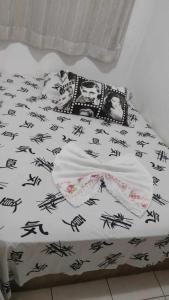 Una cama con un edredón blanco y negro. en Apto Shalom en Serra