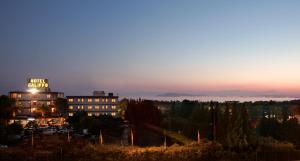 a building with a sign on top of it at night at Hotel Califfo in Quartu SantʼElena