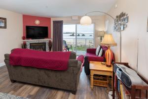 a living room with a couch and a tv at Waters Edge 207 in Lincoln City