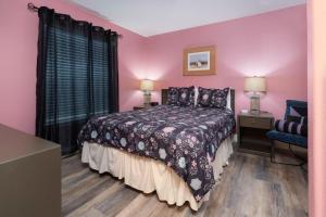 a bedroom with pink walls and a bed and a window at Waters Edge 207 in Lincoln City