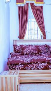 a bedroom with a bed with red curtains and a window at Select Elegant 3 Rooms 3 sized king-bed @ Abuja FCT in Abuja