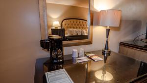 Habitación de hotel con escritorio y espejo. en G T Hotels Inn & Suites Extended Stay, en Victorville