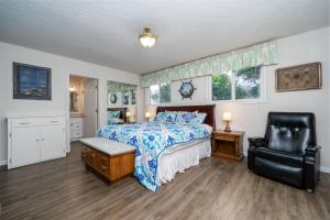 1 dormitorio con 1 cama y 1 silla en Woodley Beach House en Lincoln Beach