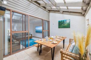a dining room with a wooden table and chairs at The Moorings 18 4 Cromarty Rd Waterfront, Pool, Wifi & AirCon in Soldiers Point