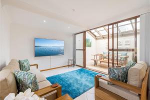 a living room with a couch and chairs and a table at The Moorings 18 4 Cromarty Rd Waterfront, Pool, Wifi & AirCon in Soldiers Point
