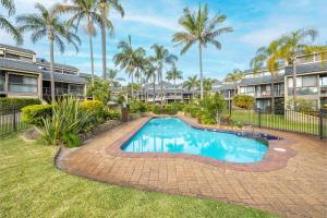 a swimming pool in a yard with palm trees at The Moorings 18 4 Cromarty Rd Waterfront, Pool, Wifi & AirCon in Soldiers Point
