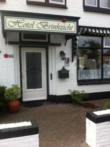 um edifício branco com um sinal na porta em Hotel Brinkzicht em De Koog