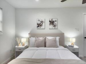 a white bedroom with a large bed with two night stands at NEW! H-Town Getaway Near Medical Center! in Houston
