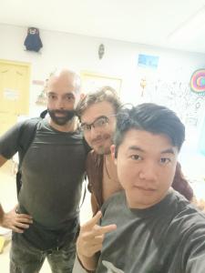 un groupe de trois hommes posant une photo dans l'établissement Youth Space, à Canton