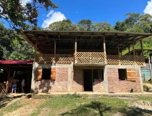 ein Backsteinhaus mit einem Holzdach in der Unterkunft Villa medici macarena - camping in San Juan de Arama