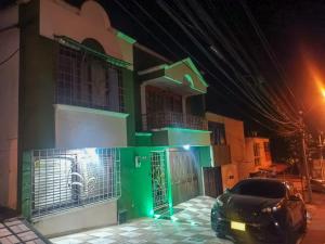 a green building with a car parked in front of it at Hotel Miluansa in Pereira