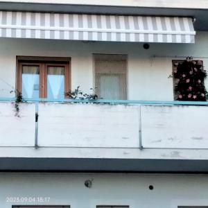 Edificio blanco con balcón y 2 ventanas en Mary BeB, en Le Torri