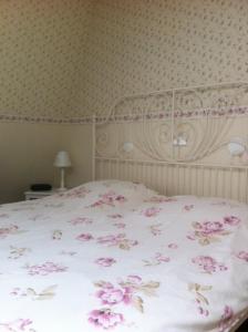 een bed met roze bloemen in een slaapkamer bij Hotel Brinkzicht in De Koog