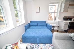 a blue couch in a living room with windows at The Elise :Home Away From Home in Washington, D.C.