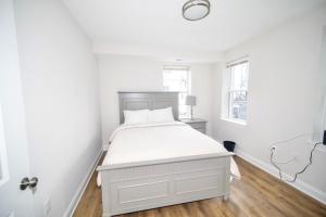 a white bedroom with a bed and a window at The Elise :Home Away From Home in Washington