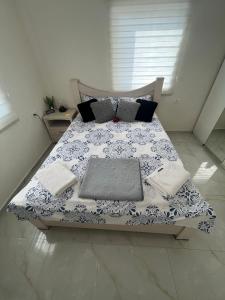 a bed with a blue and white blanket and pillows at Beachfront Studio, fully equipped in Netanya