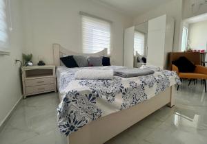 a bedroom with a bed with a blue and white comforter at Beachfront Studio, fully equipped in Netanya