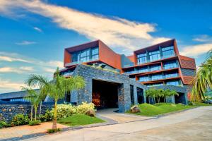 ein großes Gebäude mit Palmen davor in der Unterkunft Aria Resort & Spa - Pure Veg in Nashik