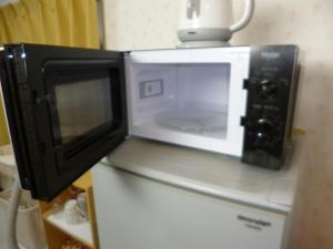 een magnetron bovenop een koelkast bij Stay Like Living IJIRI 103 in Shiobaru