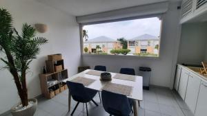 a dining room with a table and chairs and a window at Ti Koala in Les Terres Basses