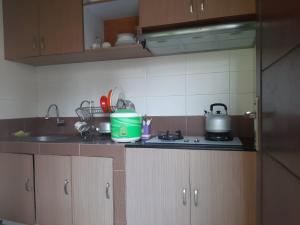 a kitchen counter with a sink and a stove at Homestay Omah Venus in Jenggrik