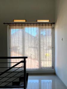 een groot raam in een kamer met een trap bij Homestay Omah Venus in Jenggrik