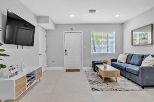 a living room with a blue couch and a tv at Sistrunk Shades Villas #3 - Brand New Townhomes Downtown Fort Lauderdale in Fort Lauderdale