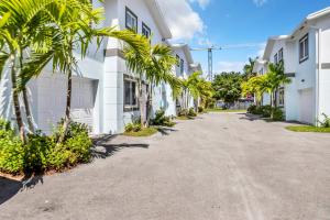 una calle con palmeras frente a edificios blancos en Sistrunk Shades Villas #3 - Brand New Townhomes Downtown Fort Lauderdale, en Fort Lauderdale