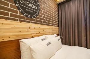 晉州的住宿－Hotel Chicago，砖墙房间的一个床位