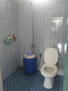a bathroom with a toilet and a blue bucket at Homestay Melty Aprianti Tanjong Tinggi in Pasarbaru