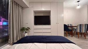 1 dormitorio con 1 cama y TV en la pared en Loft céntrico San borja - San Isidro, en Lima