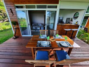 una terraza de madera con mesa y sillas de madera en Fare Juanita Piti en Opoa