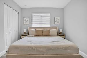 ein Schlafzimmer mit einem großen Bett mit weißen Wänden in der Unterkunft Sistrunk Shades Villa #4 - Townhome Downtown Fort Lauderdale Near Cruise Port & FLL in Fort Lauderdale