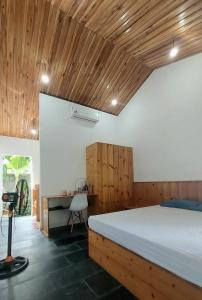 a bedroom with a large bed and a desk at Vom Vom Garden House in Da Nang