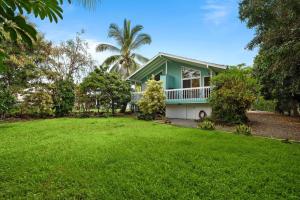 Una casa con un gran patio al frente. en New A/C Central Kona Surf House 4bd/4bth Sleeps8, en Kailua-Kona