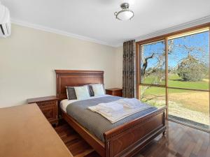 a bedroom with a bed and a large window at Aurora Cottages Bush Retreat in Halls Gap