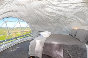 a bedroom with a bed in a dome tent at Black Label Retreats in Gisborne
