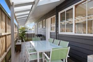 a patio with a blue table and chairs at Key Lime Retreat in Cape Woolamai