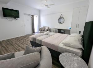a hotel room with two beds and a couch at Escape On Lake in Cairns