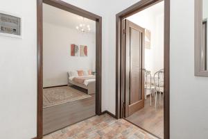 a hallway with a wooden door and a living room at Уютная Квартира Expo Boulevar in Astana