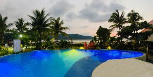 a large blue swimming pool with a view of the ocean at MB Cove in Nasugbu